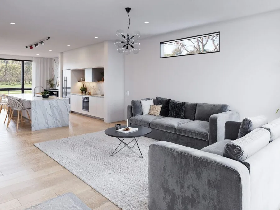 Modern open-plan living room with gray sectional sofa, marble kitchen island, and large windows overlooking a garden. (3 of 4)