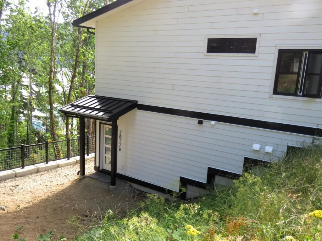 Side view of the modern home showing the entrance to the guest suite