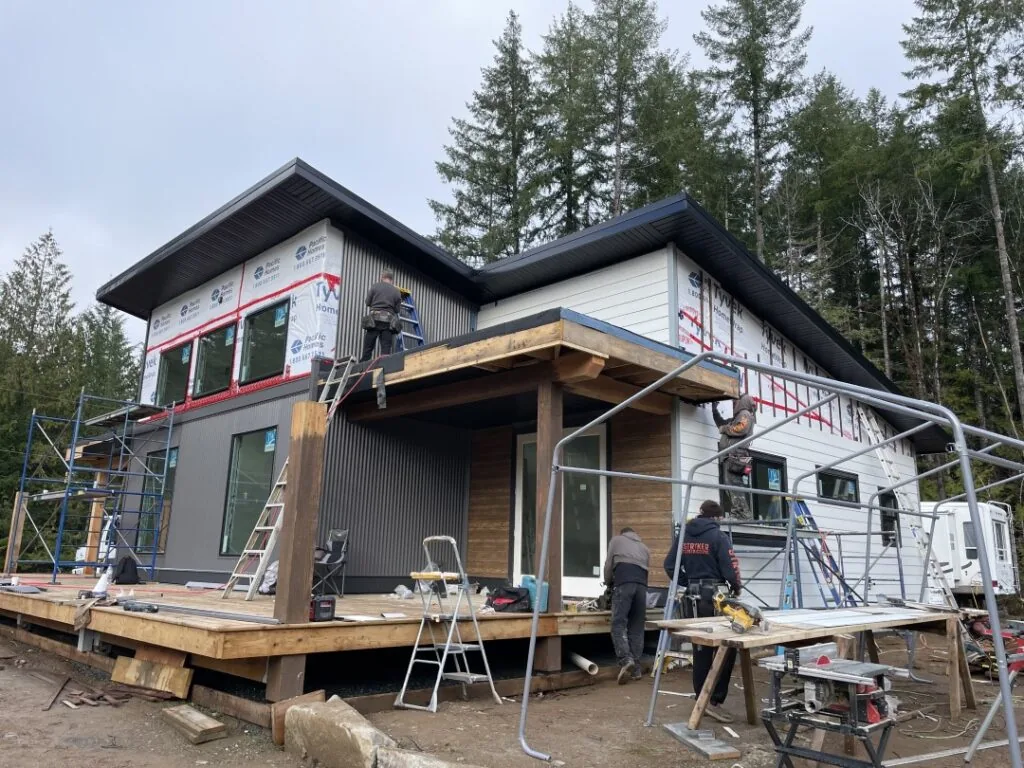 The siding is being completed on the small modern house plan